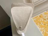 un petit objet en forme de triangle posé sur une table à côté d'une bibliothèque