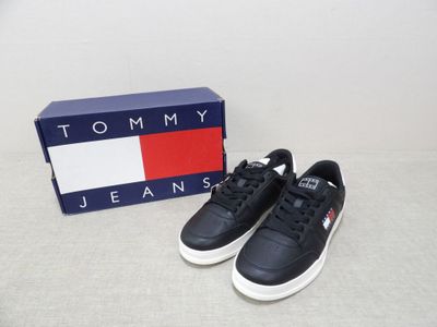 a pair of black and white sneakers sitting next to a box
