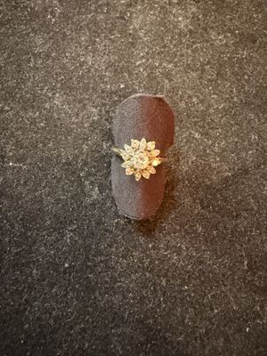 a ring with a flower on it sitting on the ground