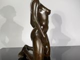 bronze sculpture of a woman sitting on a black table