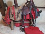 une selle de cheval avec une couverture rouge et une paire de bottes