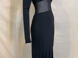 the dress is black and has long sleeves and a belt on the waist