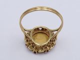a close up of a gold ring with a red stone in the center