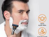 the man is shaving his beard with an electric razor