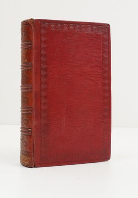 un livre rouge posé sur une table blanche