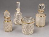 three glass bottles and a glass cup on a table