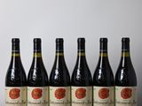 six bouteilles de vin sont alignées sur une table en bois