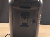une photo d'une cafetière noire posée sur une table en bois
