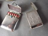 a lighter and matches in a silver case on a table