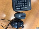 a computer keyboard and mouse on a desk with a mouse pad