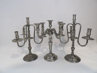 trois chandeliers en argent sur fond blanc, avec un fond blanc