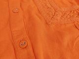 an orange shirt with a lace collar and buttons on the chest
