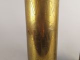 two brass vases sitting next to each other on a white surface