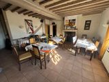 a dining room with tables and chairs and a fireplace in the background