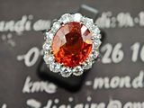 une bague sertie d'un diamant orange, posée sur un morceau de papier
