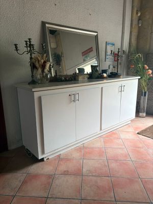 une armoire blanche surmontée d'un miroir