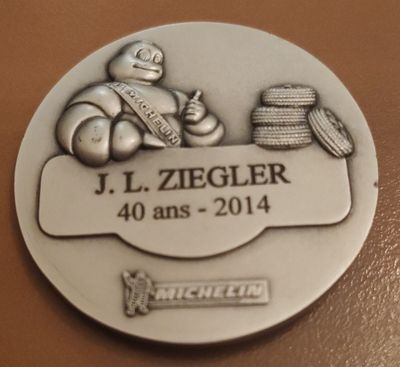 une médaille d'argent sur laquelle figure l'image d'un homme tenant une raquette de tennis