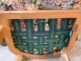 a green chair with a floral seat cover on it
