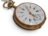 a gold pocket watch with roman numerals on it