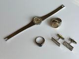 a silver watch, a cuff watch, a cuff ring, and a watch on a white surface