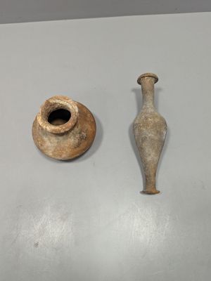 two vases sitting on a table next to each other