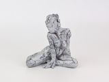 une petite statue représentant une femme assise par terre