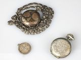 a silver pocket watch with a chain around it