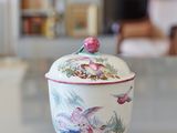 a white bowl with a bird on it sitting on a table