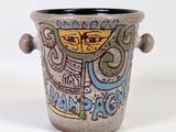 un vase avec un motif sur une surface blanche