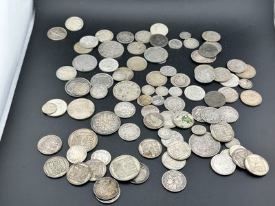 un tas de pièces d'argent posées sur une table, à côté d'un rouleau de papier