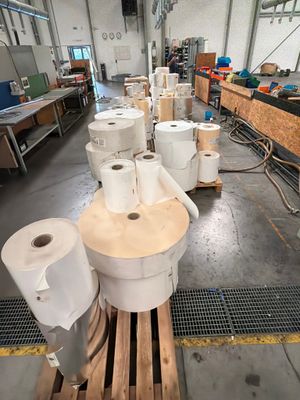 Plusieurs rouleaux de papier toilette sont alignés sur une palette dans un entrepôt
