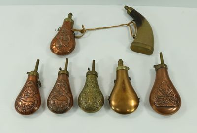 several different types of brass bells on a white surface
