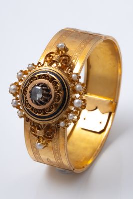 Gros plan sur une bague en or ornée d'une pierre noire