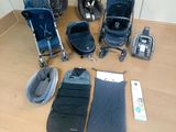 une poussette, un siège auto, un sac de couchage et un matelas de sol posés sur une table