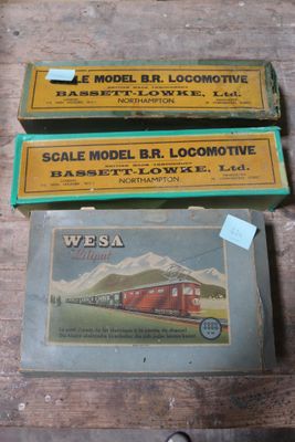 trois boîtes de locomotives de modélisme ferroviaire posées sur une table en bois
