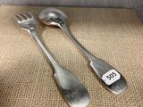 two silver spoons and a fork on a table