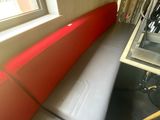 un banc rouge et noir dans une pièce dotée d'une fenêtre