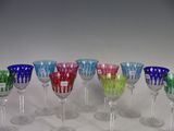 many different colored wine glasses in a row on the table