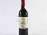 a bottle of red wine sitting on top of a white table
