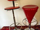 two red stools sitting next to each other on a rug