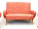 three chairs and a couch in a room with a white wall