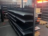 many empty shelves in a store with signs on them