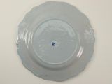 a white plate with a blue flower on it