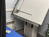 une table bleue sur laquelle se trouve un tableau blanc, dans une pièce