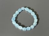 a close up of a bracelet with blue beads on a table