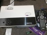 a laptop computer sitting on top of a table with a remote