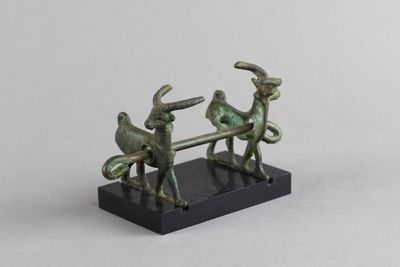 une figurine en bronze représentant deux hommes assis sur un banc