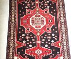 un tapis rouge et noir sur un sol blanc
