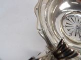 a silver plate with a flower on it on a table