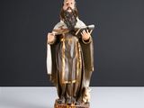 une statue représentant un homme tenant un livre et un chien